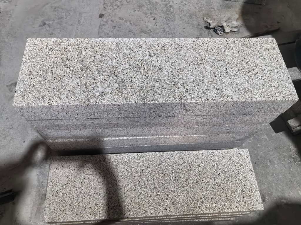 Granite paving unit with a bush-hammered top and machine-cut side faces for regular joints.