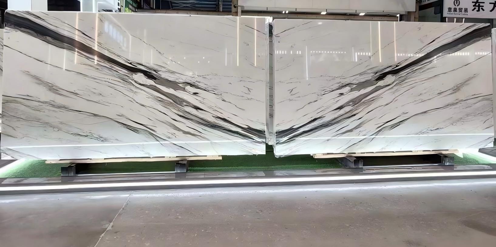 Bookmatched Oriental Calacatta White marble slabs with bold black movement across a clean white background