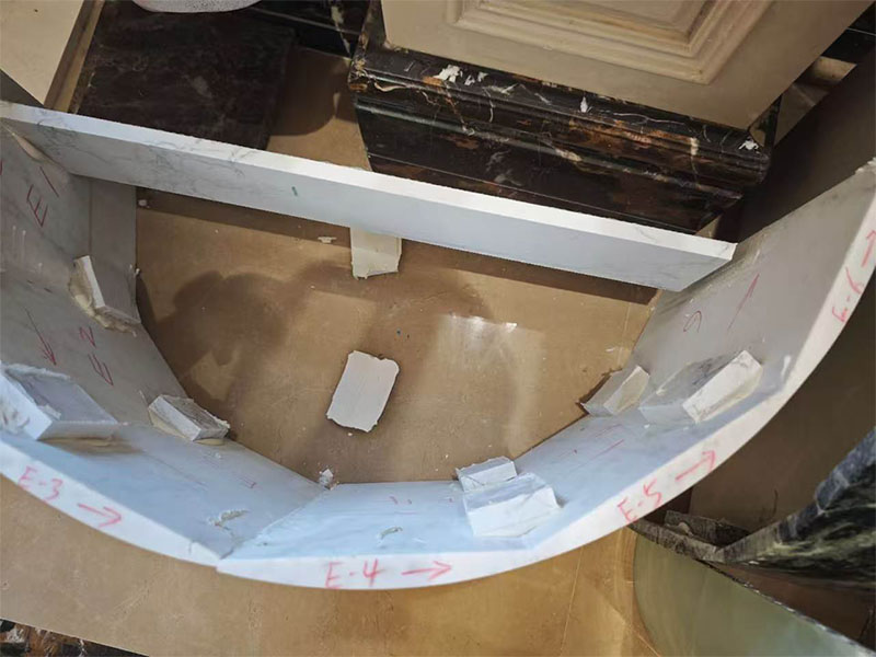 Curved marble construction made from joined slab segments.