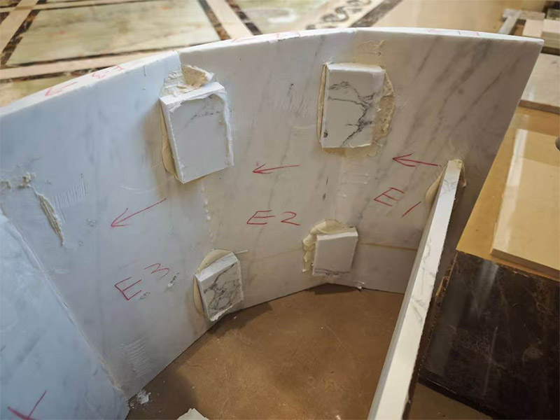 Curved marble assembled from cut stone slab sections during Excellent Stone production.